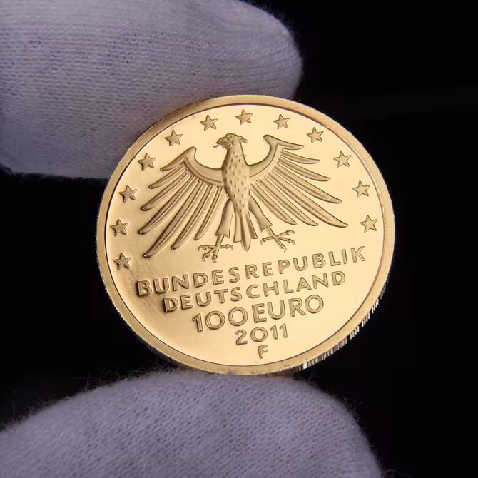 Goldmünze 100 Euro UNESCO Wartburg 2011 Rückseite in Handschuh gehalten