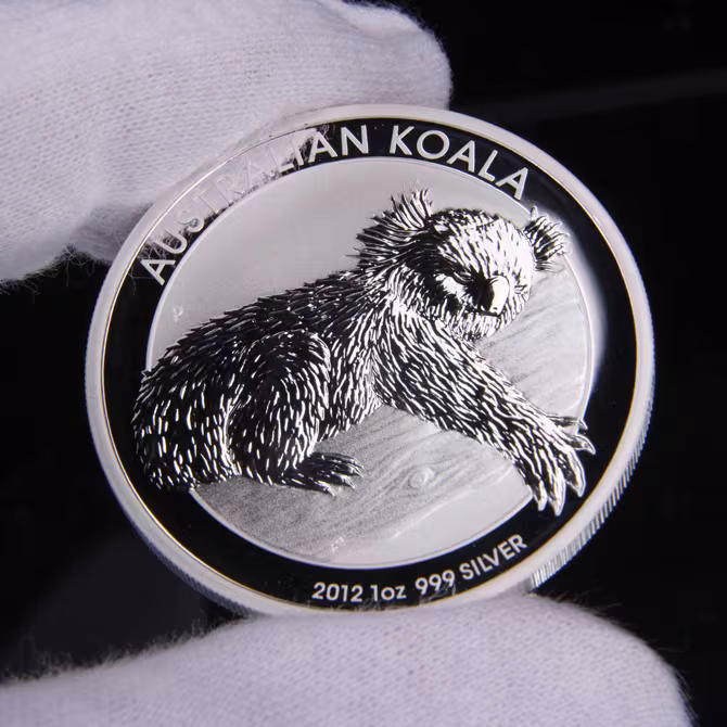 Perth Mint Australian Koala Silbermuenze 1 oz 2012 Vorderseite schlafender Koala AUSTRALIAN KOALA in weissen Handschuhen gehalten