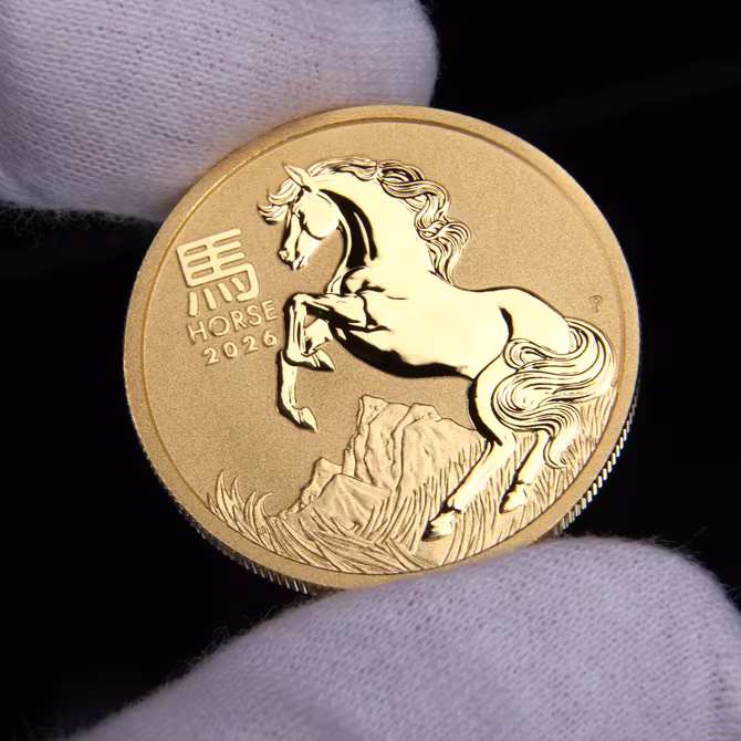 Perth Mint Lunar III Goldmuenze 1 oz Pferd 2026 Vorderseite in weissen Handschuhen gehalten